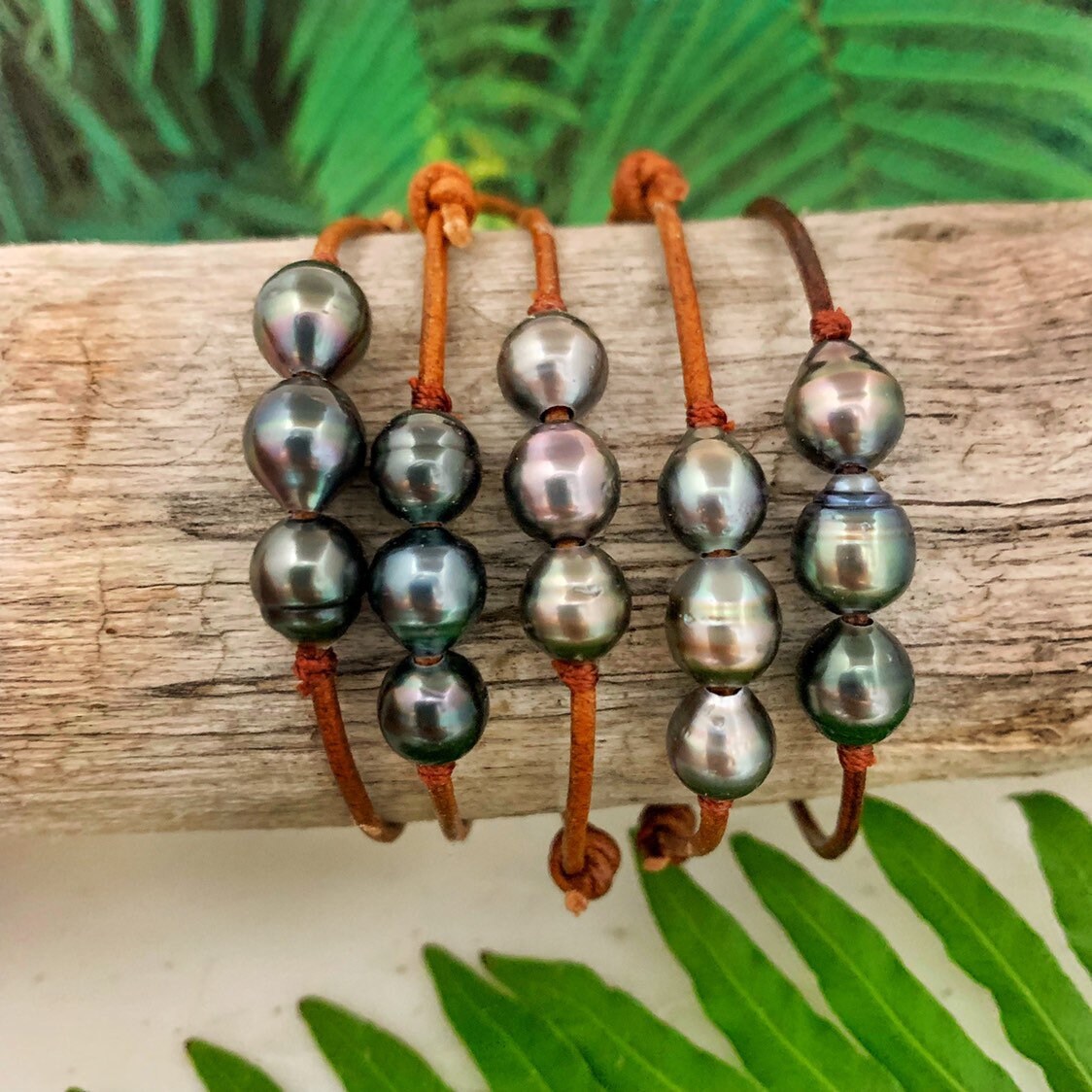Unisex leather bracelet featuring three Tahitian pearls on adjustable brown cord