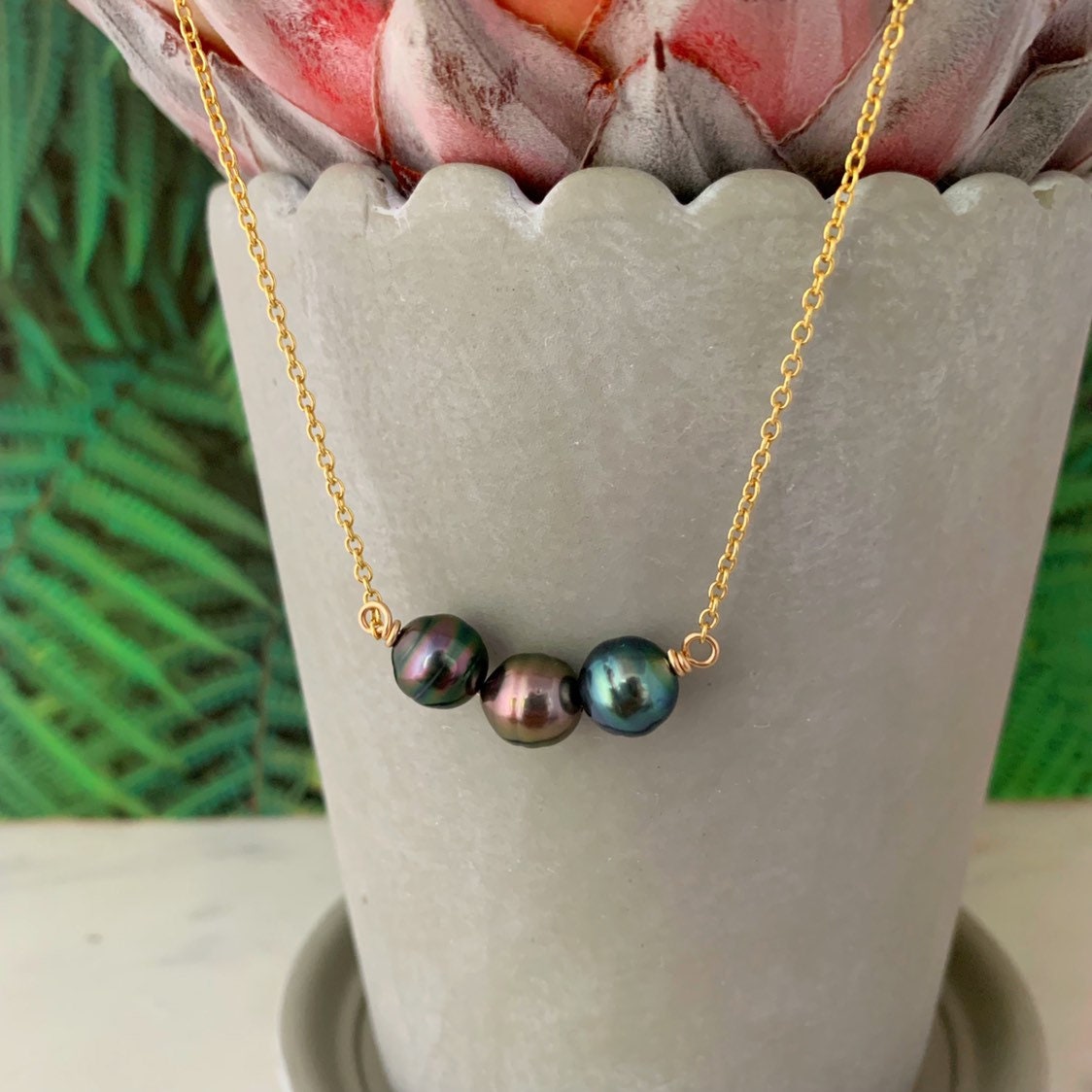 Tahitian pearl necklace with three black pearls nestled closely in a gentle U-shape on a 14k yellow gold filled chain, handmade minimalist jewelry from Hawaii
