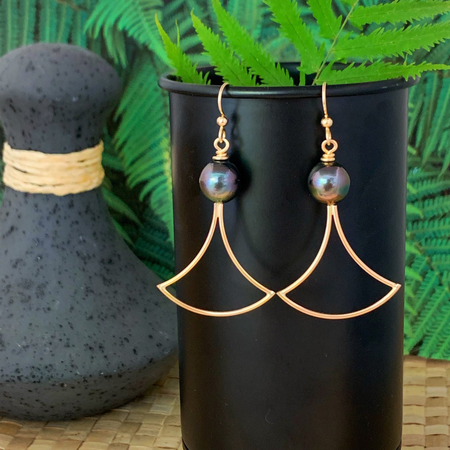 Handmade gold vermeil earrings featuring black Tahitian pearls and a poi pounder–inspired design rooted in Hawaiian tradition.