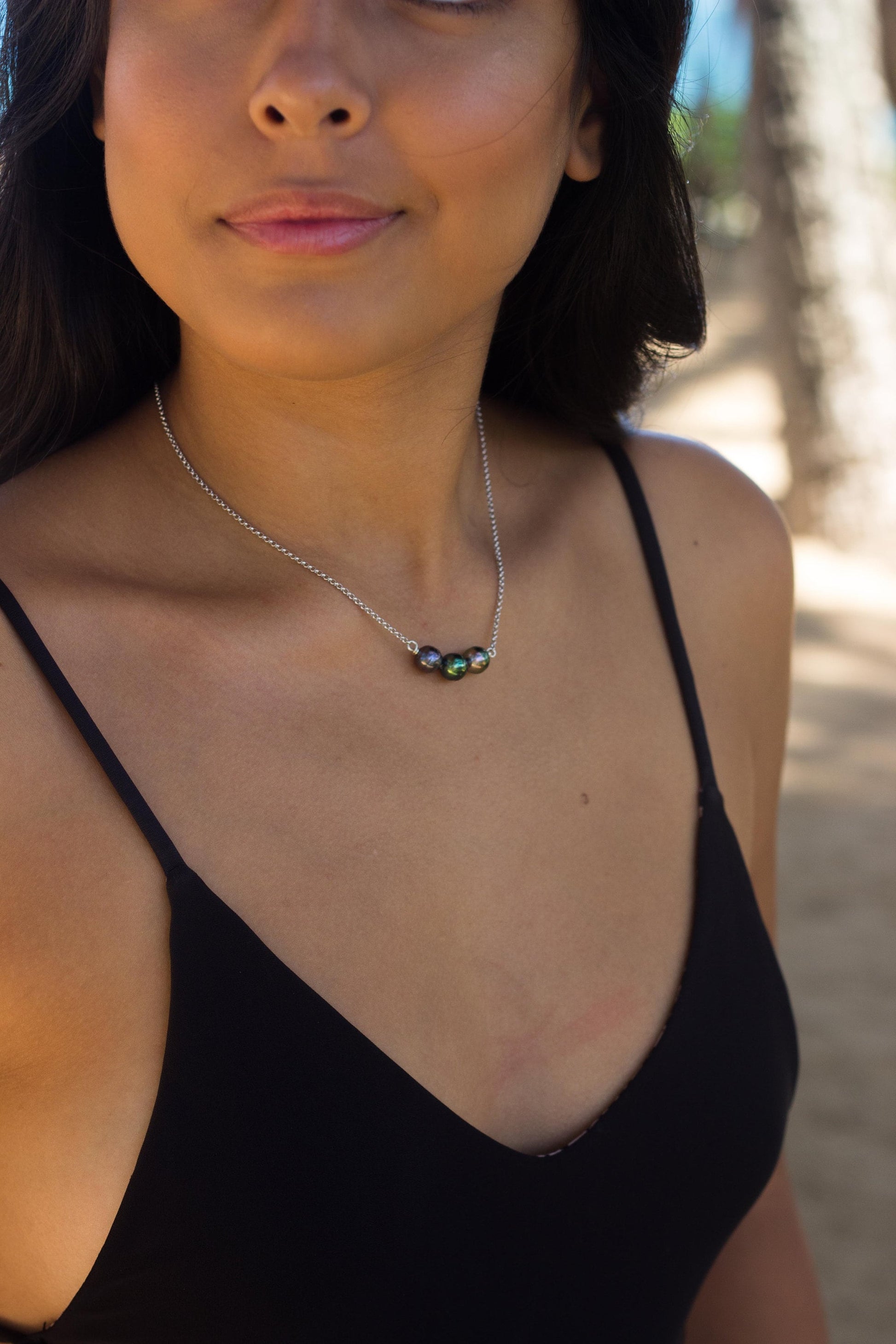 Tahitian pearl necklace with three black pearls nestled closely in a gentle U-shape on a sterling silver chain, handmade minimalist jewelry from Hawaii