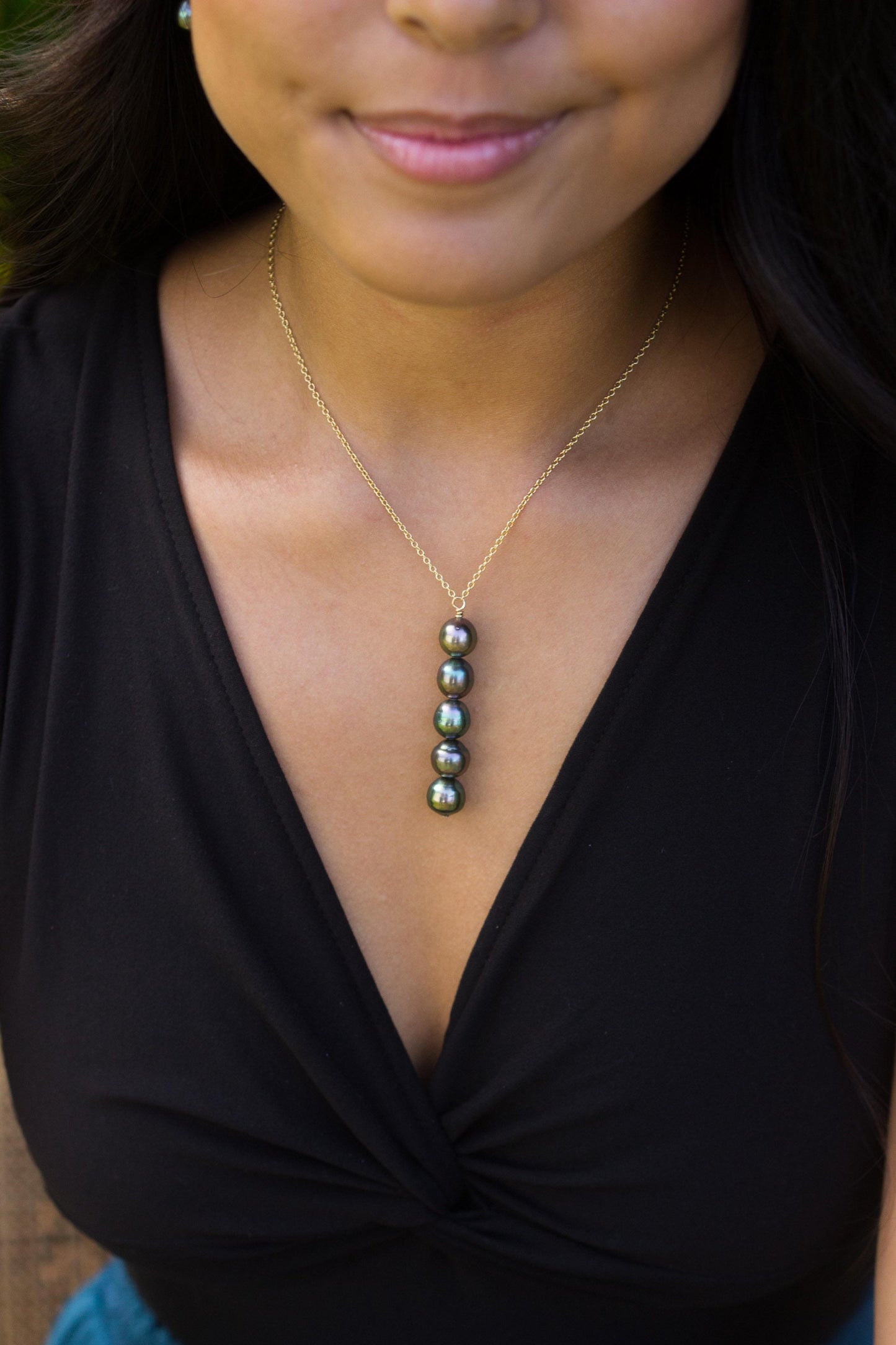 Minimalist Y necklace with five vertically stacked Tahitian baroque pearls on a chain.