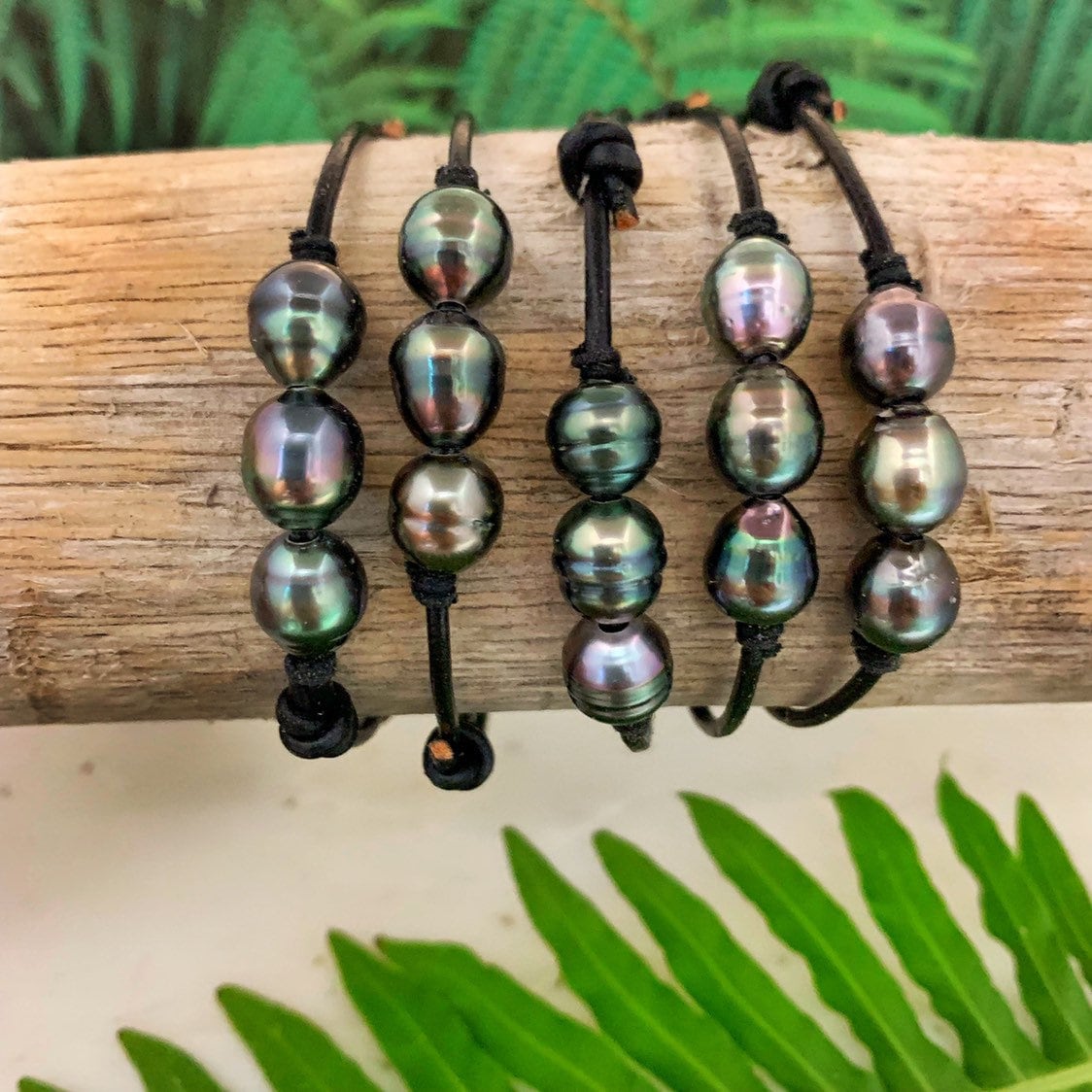 Unisex leather bracelet featuring three Tahitian pearls on adjustable black cord