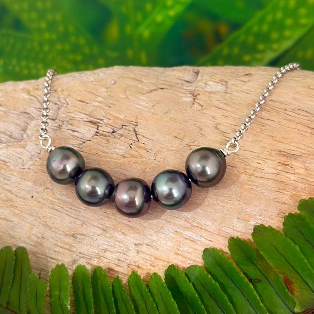 Tahitian pearl necklace with five pearls arranged in a delicate U-bar design on a sterling silver chain, resting elegantly along the neckline.