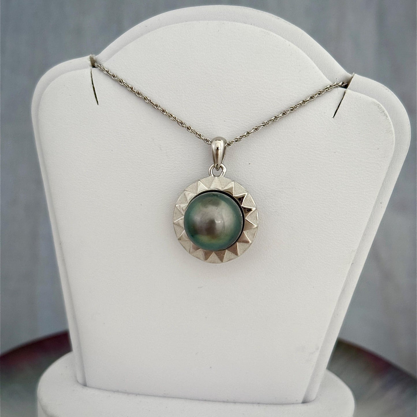 Sterling silver pendant in a radiant sun design with a large 12mm+ Tahitian pearl at the center